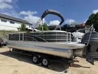 Slide: The Image of 2025 Bennington 25 SXSR pontoon boat on trailer, parked outdoors under clear sky. - 7