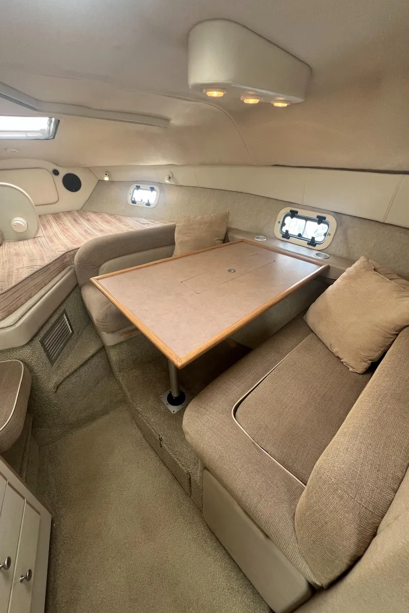 Slide: The Image of 1997 Maxum 2800 SCR cabin interior with seating, table, and cushions. - 11