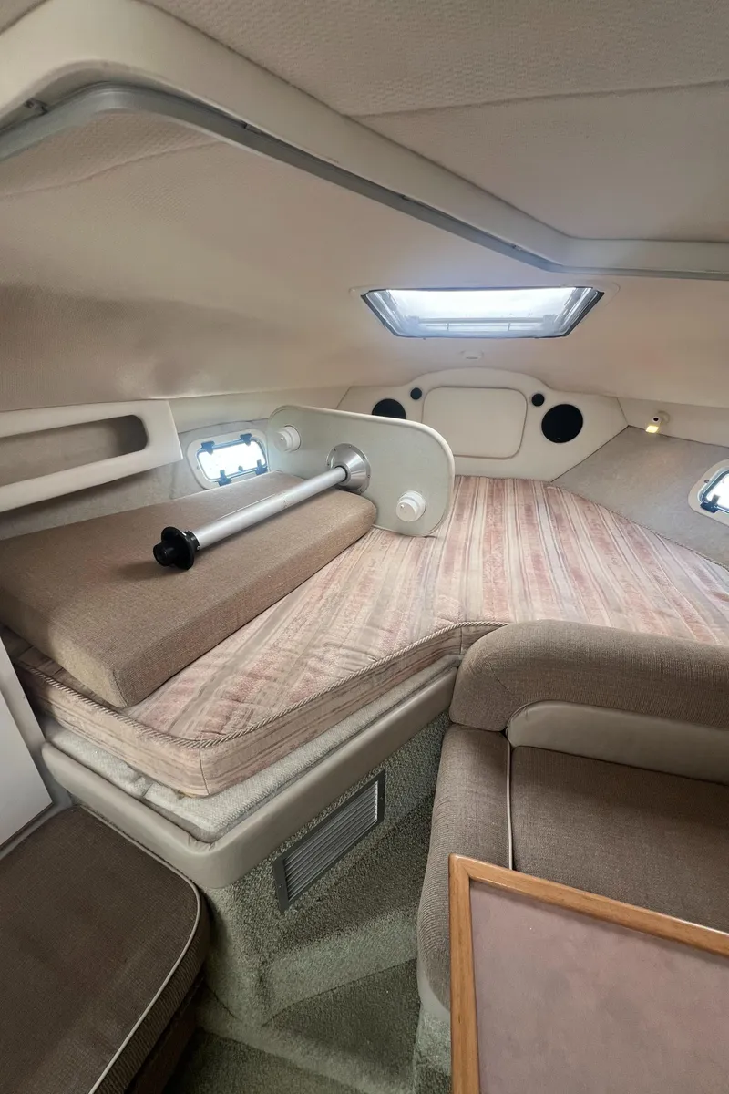 Slide: The Image of Interior cabin of a 1997 Maxum 2800 SCR boat with cushioned seating and windows. - 12