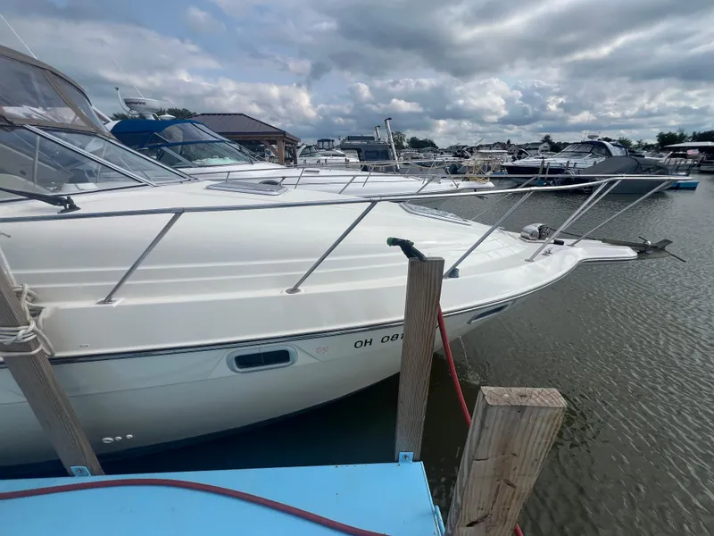 Slide: The Image of 1997 Maxum 2800 SCR boat docked at a marina under cloudy skies. - 2