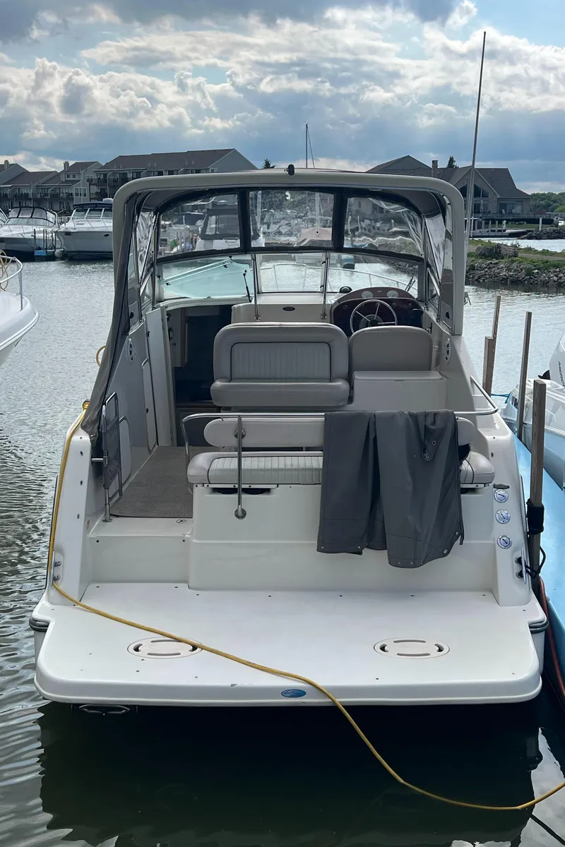 Slide: The Image of 1997 Maxum 2800 SCR boat docked at marina, featuring spacious seating and covered cockpit. - 4