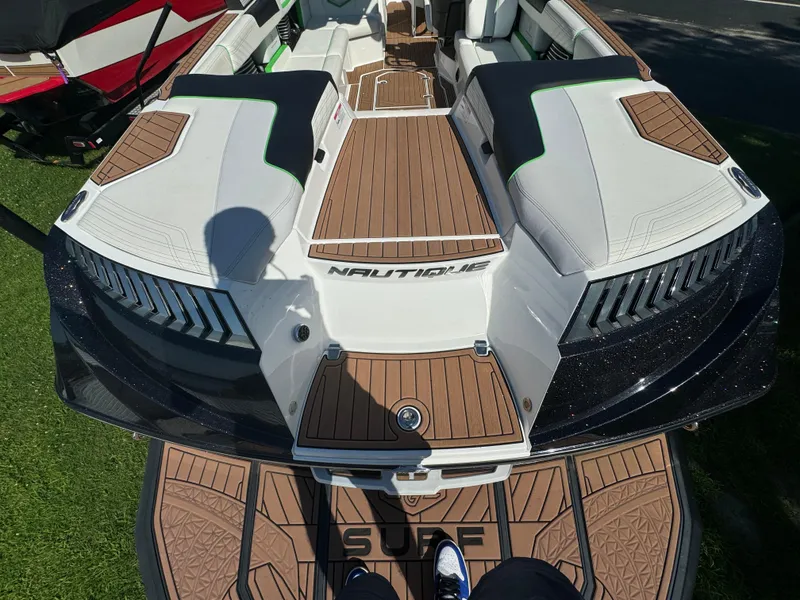 Slide: The Image of 2017 Nautique Super Air Nautique G25 boat interior with teak flooring and cushioned seating. - 5