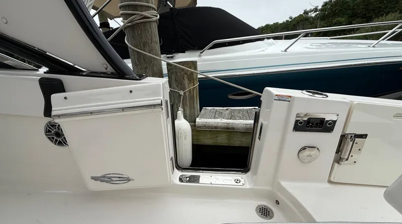 Slide: The Image of 2021 Chaparral 300 OSX boat docked, showing open side door and control panel. - 12