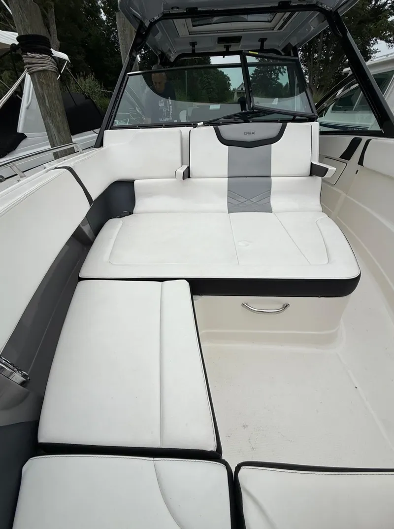 Slide: The Image of 2021 Chaparral 300 OSX boat interior with white cushioned seating. - 18