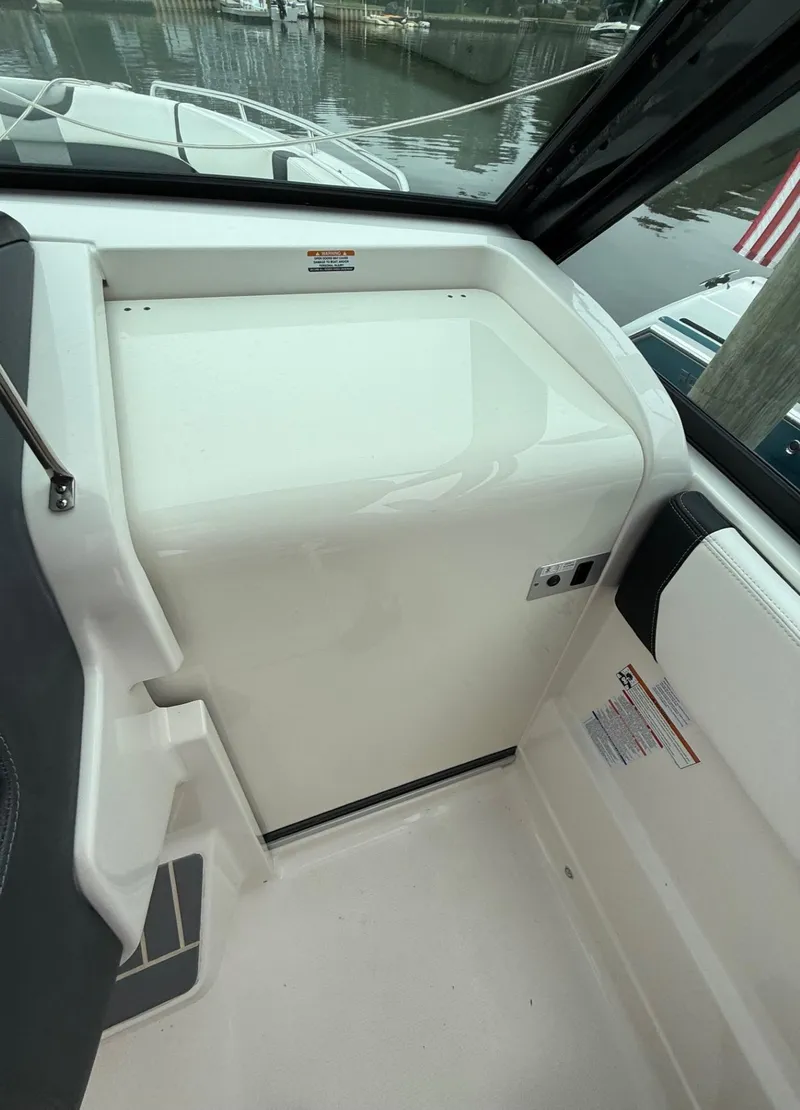 Slide: The Image of 2021 Chaparral 300 OSX boat interior, featuring sleek white surfaces and modern design elements. - 23