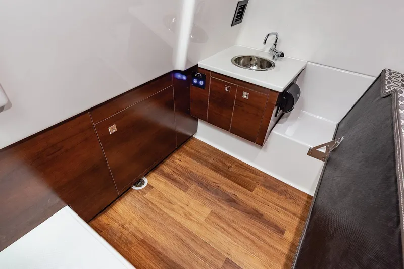 Slide: The Image of Manufacturer Provided Image: 2021 Chaparral 300 OSX boat interior with wooden flooring and compact sink. - 24
