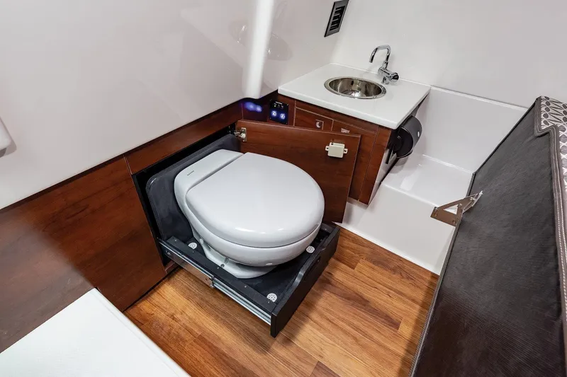 Slide: The Image of Manufacturer Provided Image: 2021 Chaparral 300 OSX boat bathroom with toilet, sink, and wooden flooring. - 25