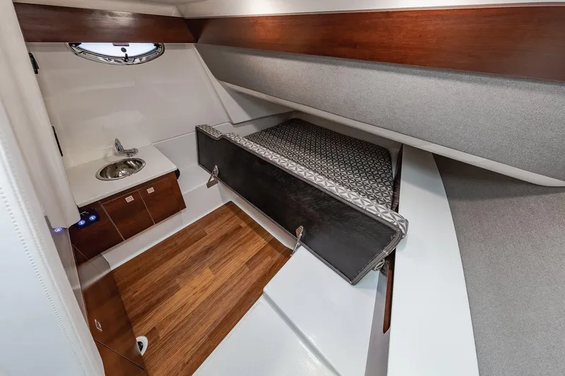 Slide: The Image of Manufacturer Provided Image: 2021 Chaparral 300 OSX cabin interior with bed, sink, and wooden flooring. - 26