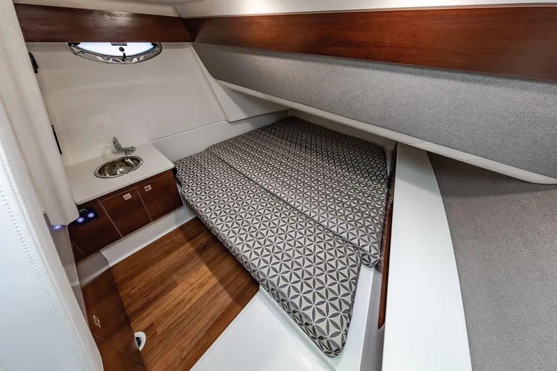 Slide: The Image of Manufacturer Provided Image: 2021 Chaparral 300 OSX cabin interior with bed, sink, and wooden flooring. - 27