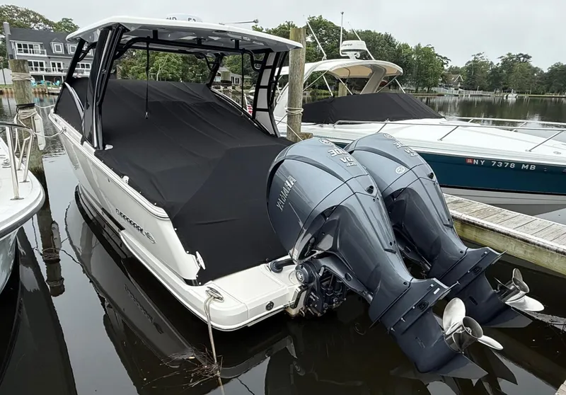 Slide: The Image of 2021 Chaparral 300 OSX boat with dual Yamaha outboard engines docked in a marina. - 5