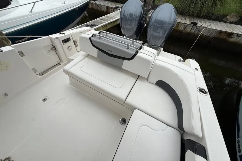 Slide: The Image of 2021 Chaparral 300 OSX boat with white seating and dual outboard motors. - 9