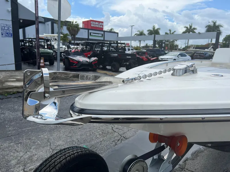 Slide: The Image of 2022 ShearWater 250 Carolina boat with anchor, parked at dealership, palm trees in background. - 4