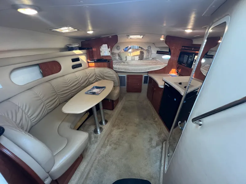 Slide: The Image of Interior of 2003 Rinker 312 Fiesta Vee boat with seating, table, and kitchenette. - 11
