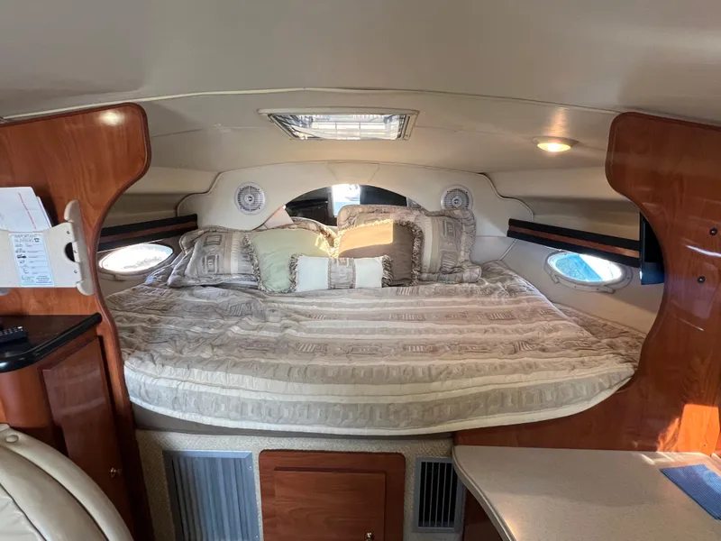 Slide: The Image of Cozy cabin interior of 2003 Rinker 312 Fiesta Vee with plush bedding and wood accents. - 14