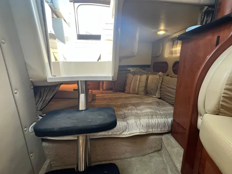 Slide: The Image of Interior cabin of a 2003 Rinker 312 Fiesta Vee boat, featuring cozy bedding and seating. - 16