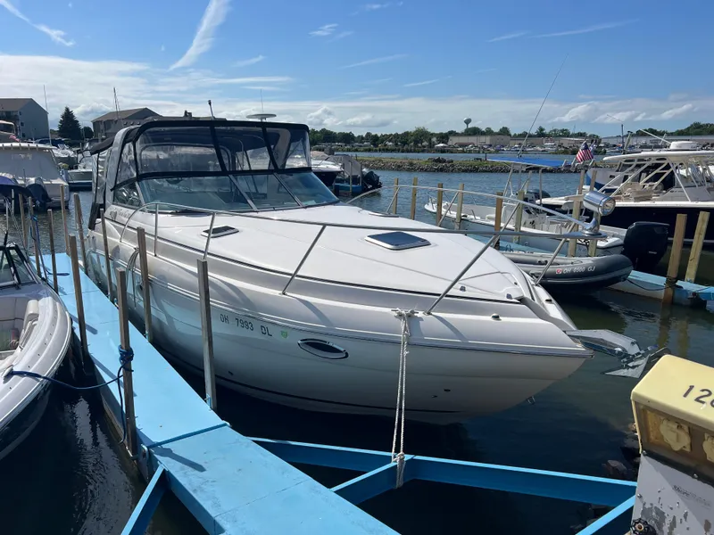 Slide: The Image of 2003 Rinker 312 Fiesta Vee boat docked at marina under clear blue sky. - 2