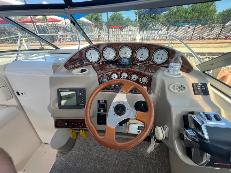 Slide: The Image of 2003 Rinker 312 Fiesta Vee boat dashboard with wood accents and navigation equipment. - 7