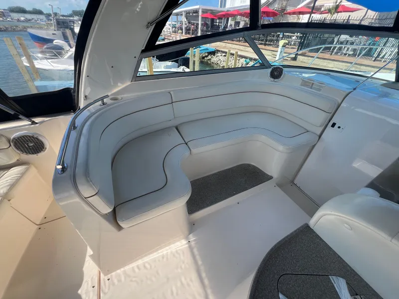 Slide: The Image of 2003 Rinker 312 Fiesta Vee boat interior with white seating and waterfront view. - 8