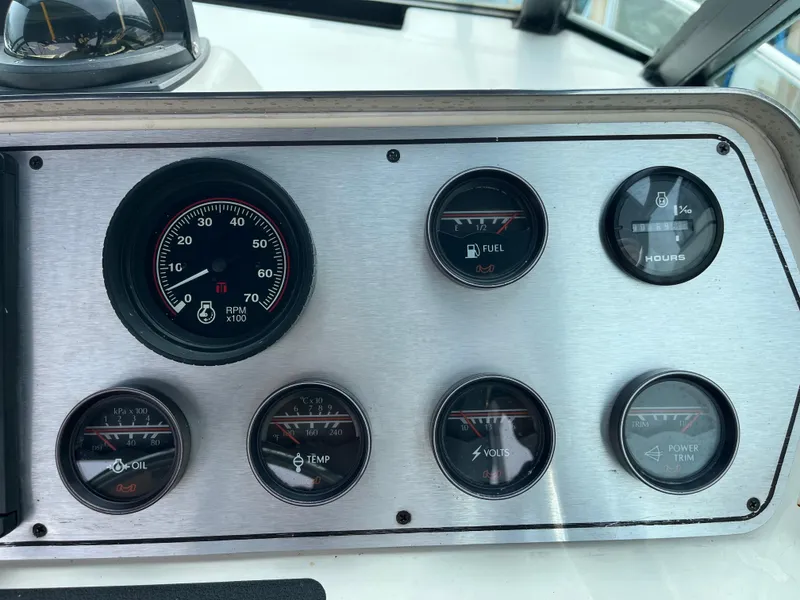 Slide: The Image of 1986 Tiara Yachts Continental dashboard with RPM, fuel, hours, oil, temperature, volts, and power trim gauges. - 11
