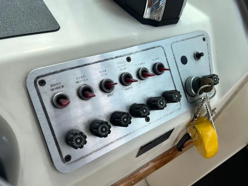 Slide: The Image of Control panel of a 1986 Tiara Yachts Continental with switches and keychain. - 14