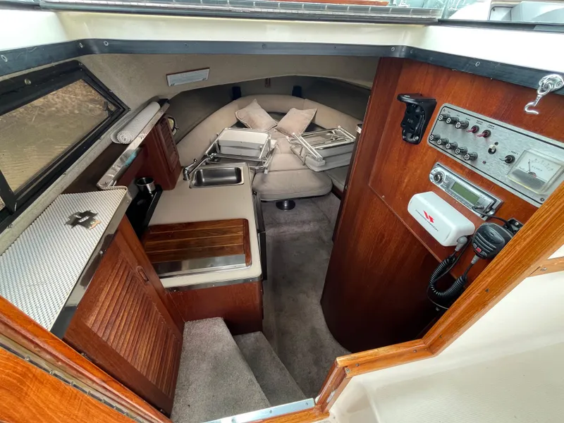 Slide: The Image of Interior of a 1986 Tiara Yachts Continental, featuring a compact cabin with wood accents. - 15