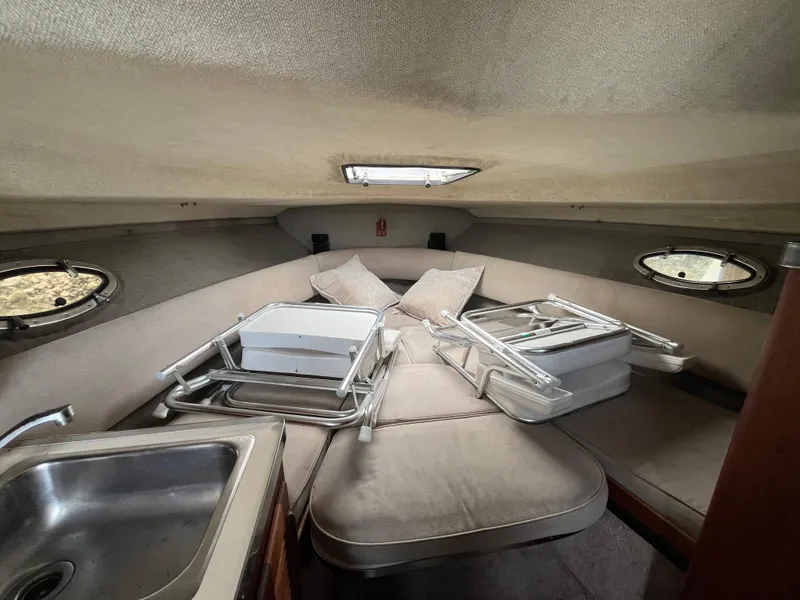 Slide: The Image of 1986 Tiara Yachts Continental cabin interior with sink, cushions, and folded chairs. - 18