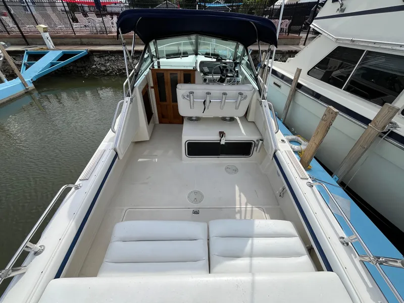 Slide: The Image of 1986 Tiara Yachts Continental boat interior with seating and helm, docked at marina. - 5