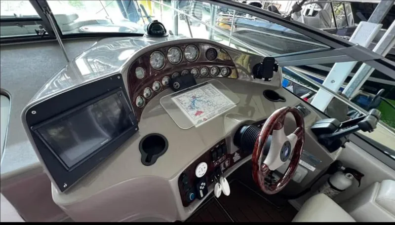 Slide: The Image of 2003 Four Winns 328 Vista boat dashboard with steering wheel and navigation instruments. - 14