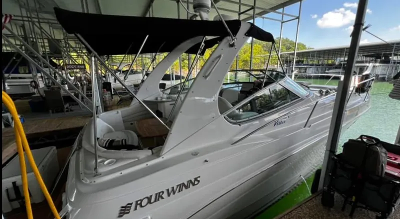 Slide: The Image of 2003 Four Winns 328 Vista boat docked under a canopy, with black bimini top. - 4