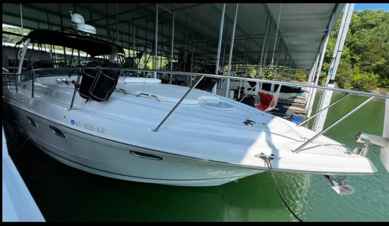 Slide: The Image of 2003 Four Winns 328 Vista boat docked in a marina, featuring sleek white design. - 5