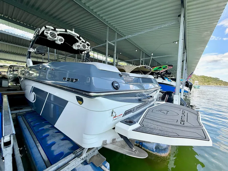 Slide: The Image of 2017 Centurion Ri237 boat docked under a covered marina, showcasing sleek design and features. - 19