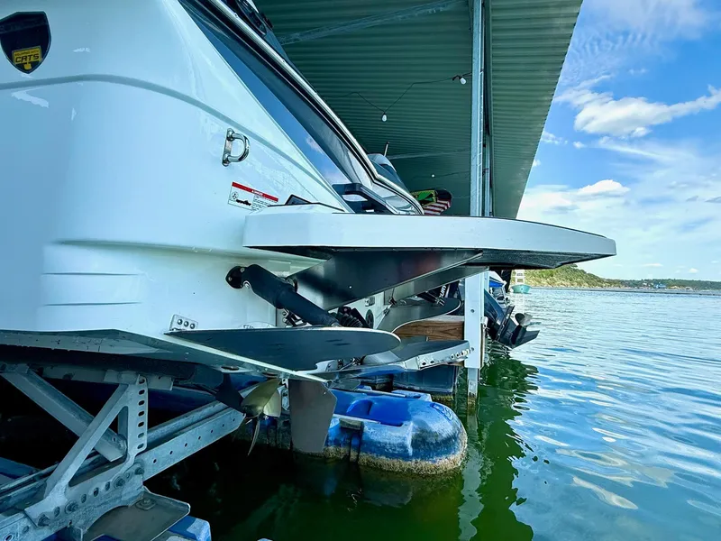 Slide: The Image of 2017 Centurion Ri237 boat docked on calm water under a covered structure. - 21