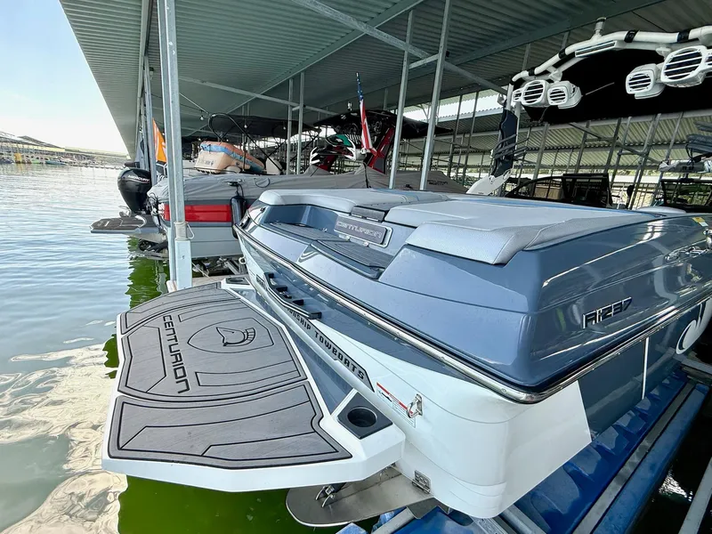 Slide: The Image of 2017 Centurion Ri237 boat docked in a covered marina, rear view. - 22