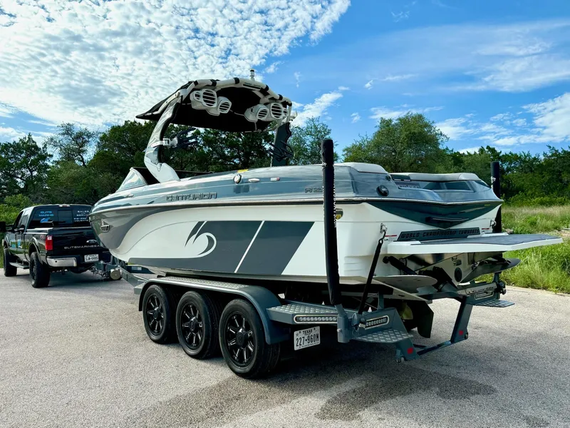 Slide: The Image of 2017 Centurion Ri237 boat on trailer, parked outdoors under a blue sky. - 26