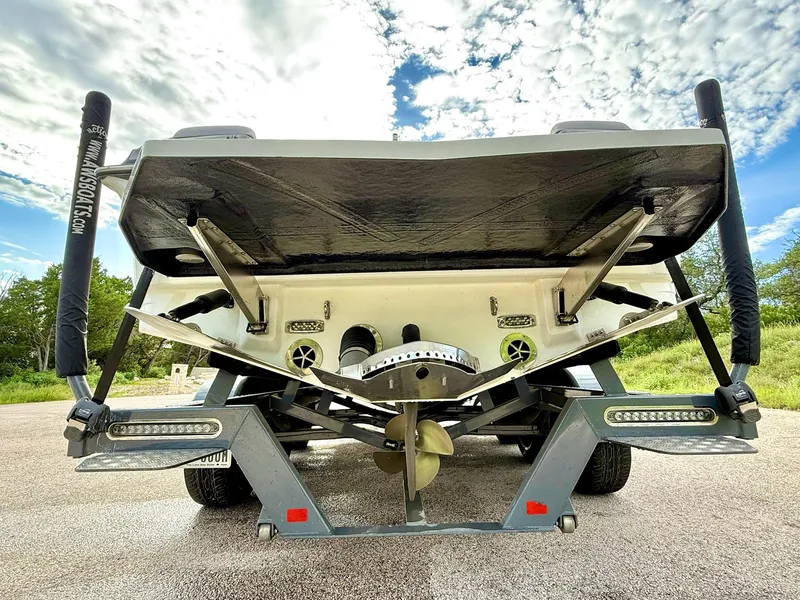 Slide: The Image of 2017 Centurion Ri237 boat rear view, showcasing propeller and wakeboard features under a cloudy sky. - 27