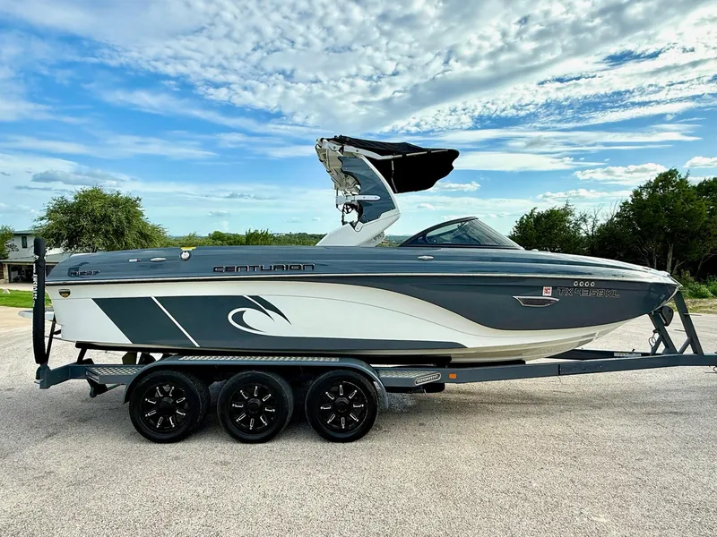 Slide: The Image of 2017 Centurion Ri237 boat on trailer under a blue sky. - 29