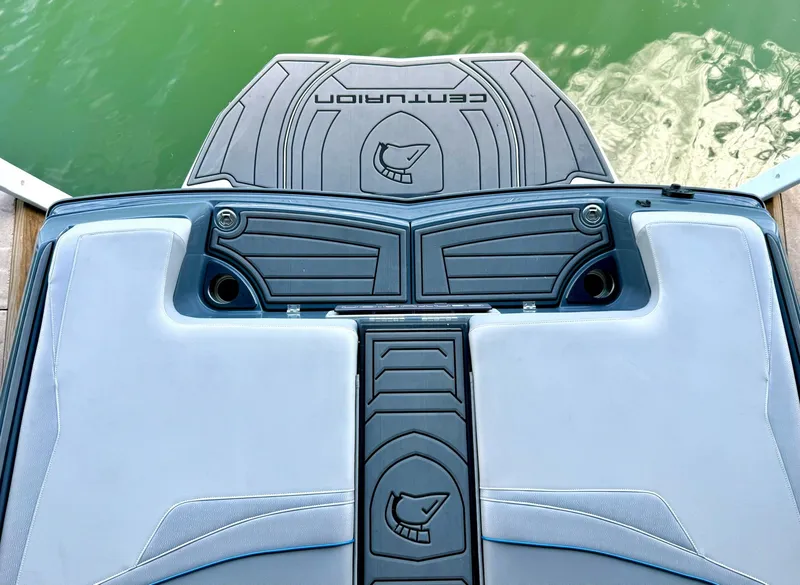 Slide: The Image of 2017 Centurion Ri237 boat interior with sleek design and logo, near green water. - 31