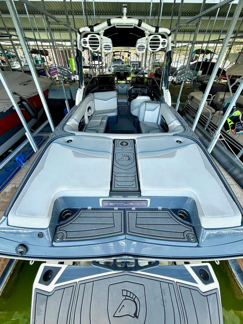 Slide: The Image of 2017 Centurion Ri237 boat with spacious seating and modern design in a covered dock. - 33
