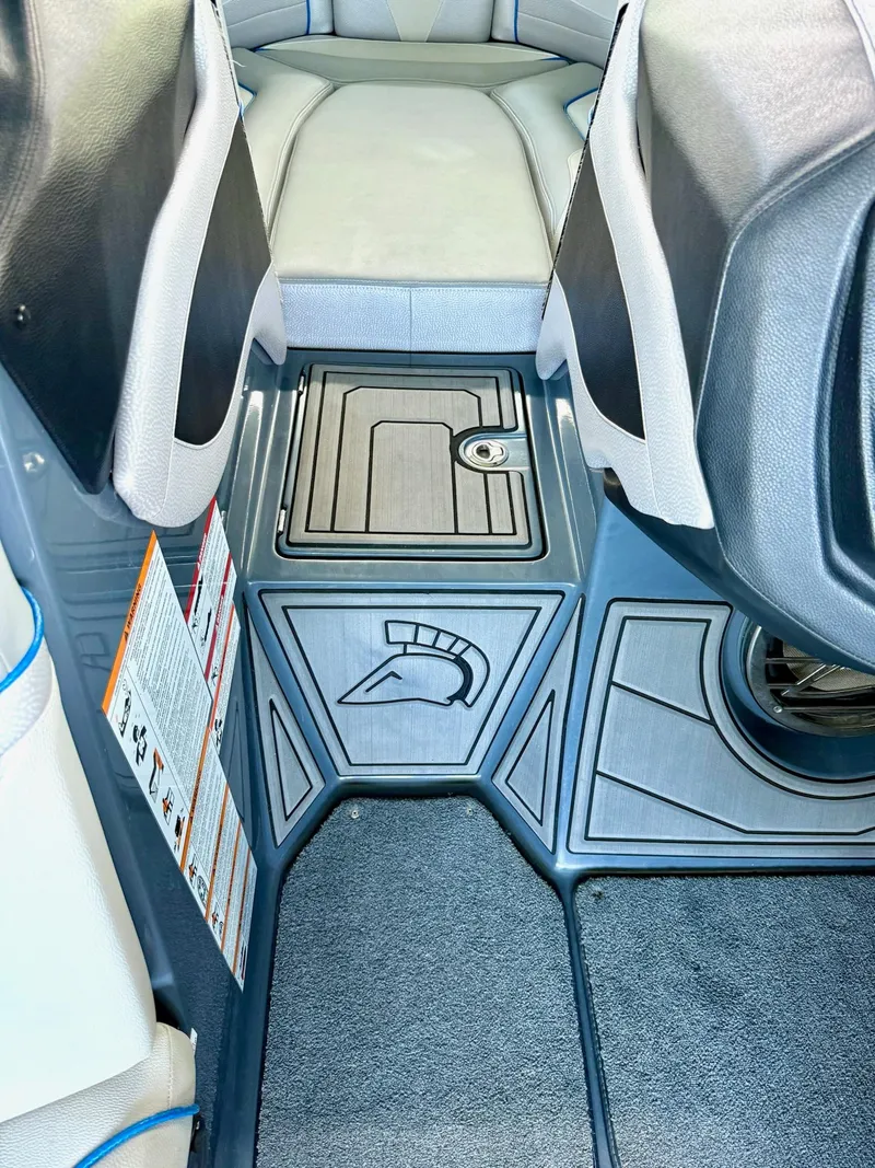 Slide: The Image of Interior of a 2017 Centurion Ri237 boat, featuring sleek seating and storage compartment. - 49