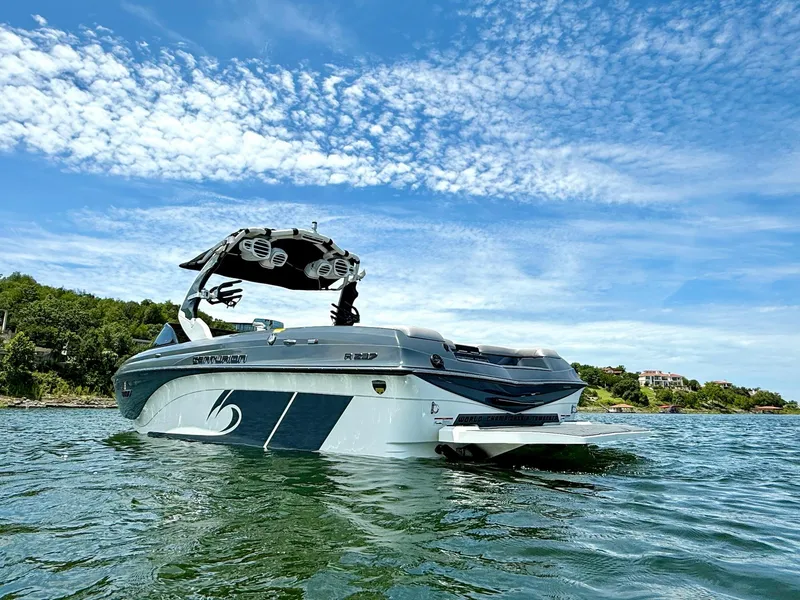 Slide: The Image of 2017 Centurion Ri237 boat on water under a clear blue sky. - 7