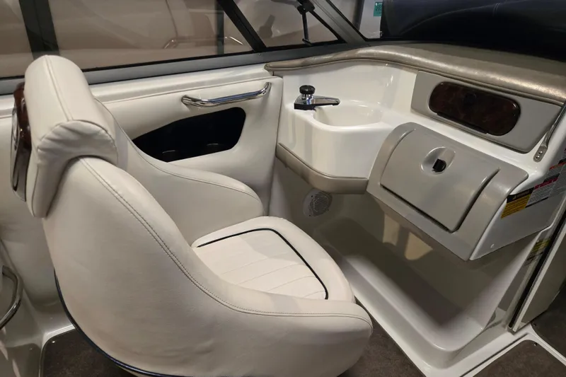 Slide: The Image of 2006 Ebbtide 2300 BRL boat interior with white seating and dashboard. - 13