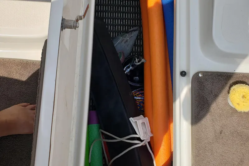 Slide: The Image of Storage compartment in a 2006 Ebbtide 2300 BRL boat with various boating accessories. - 18