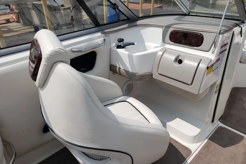Slide: The Image of 2006 Ebbtide 2300 BRL dashboard with wood trim, steering wheel, and radio controls. - 6