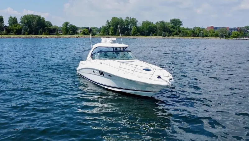 Slide: The Image of 2006 Sea Ray 44 Sundancer yacht cruising on a serene lake. - 11