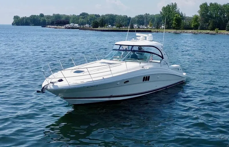 Slide: The Image of 2006 Sea Ray 44 Sundancer yacht cruising on a serene lake. - 13