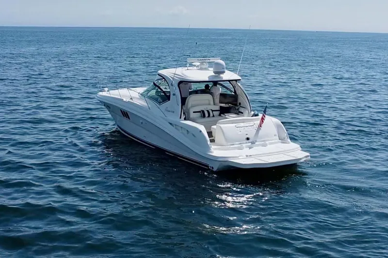 Slide: The Image of 2006 Sea Ray 44 Sundancer yacht cruising on open water. - 19