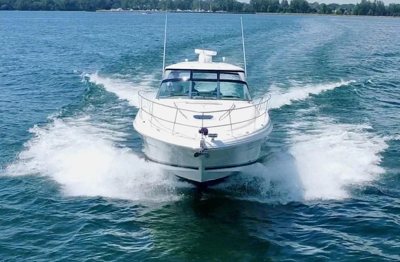 Slide: The Image of 2006 Sea Ray 44 Sundancer cruising on open water, creating a dynamic wake. - 2