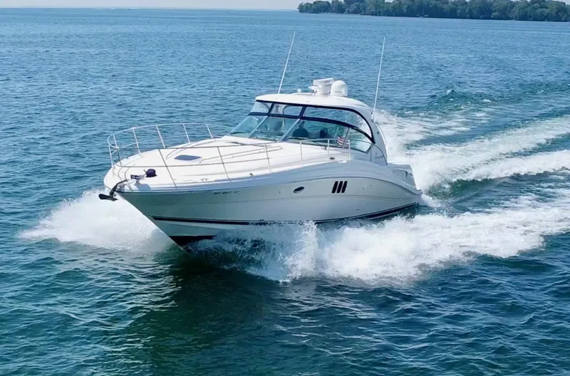 Slide: The Image of 2006 Sea Ray 44 Sundancer cruising on open water, creating a dynamic wake. - 3