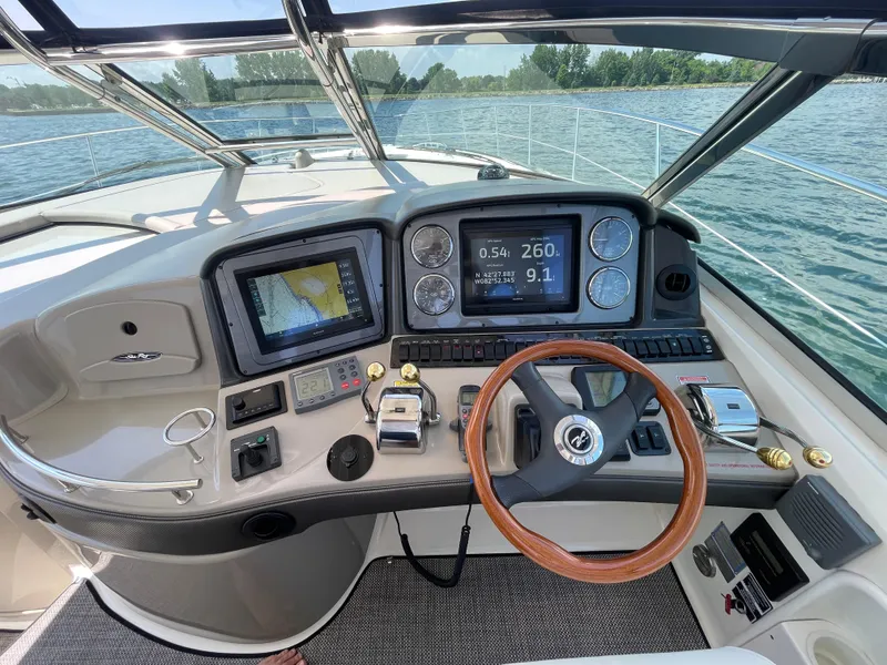 Slide: The Image of Helm of 2006 Sea Ray 44 Sundancer with navigation equipment and wooden steering wheel. - 34