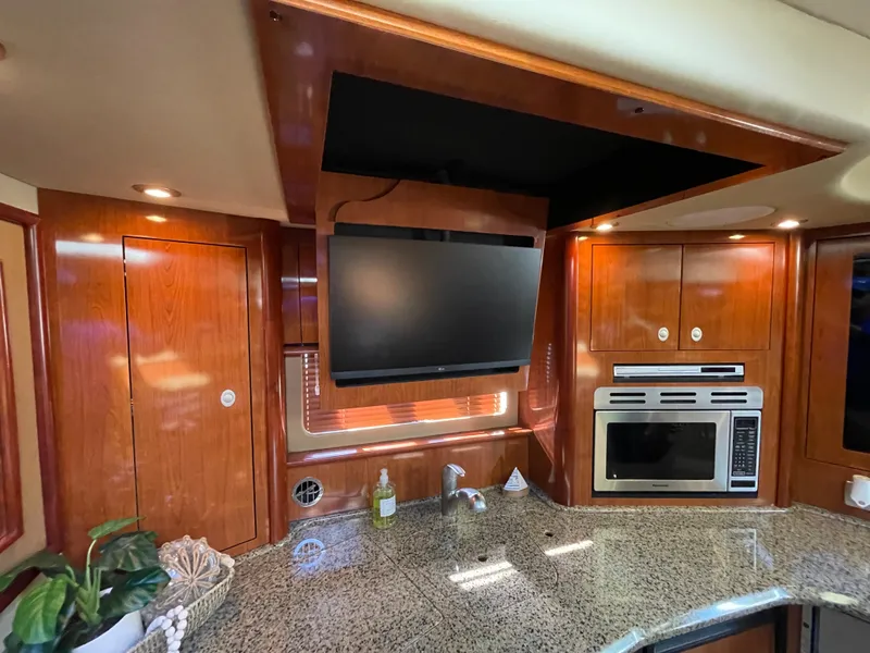 Slide: The Image of Luxurious 2006 Sea Ray 44 Sundancer yacht interior with modern kitchen and TV. - 46